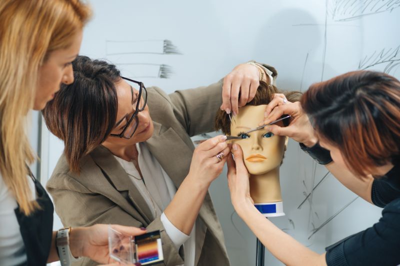 Female students practicing eyelash extension application on Silicone Mannequin Head